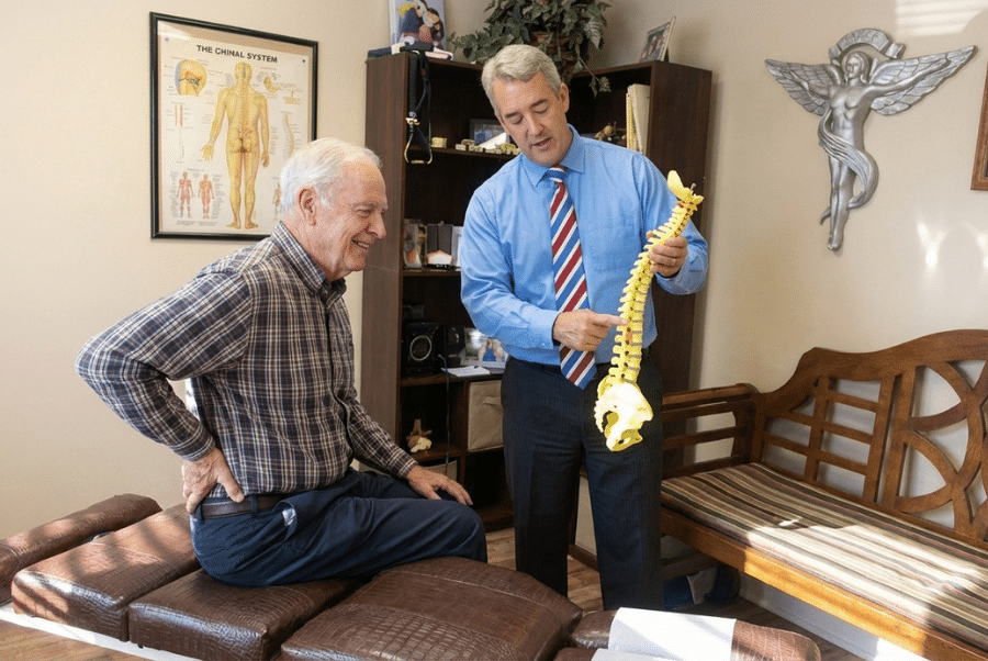 chiropractor explaining arthritis relief chiropractic treatment for seniors